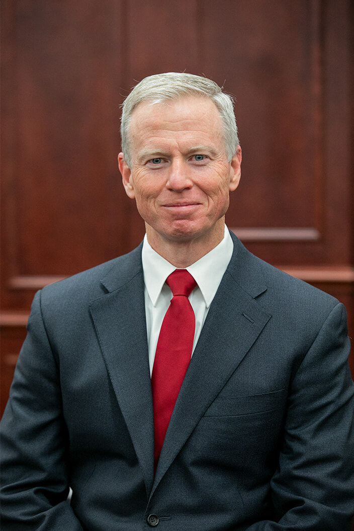 Headshot of George Brauchler with red tie